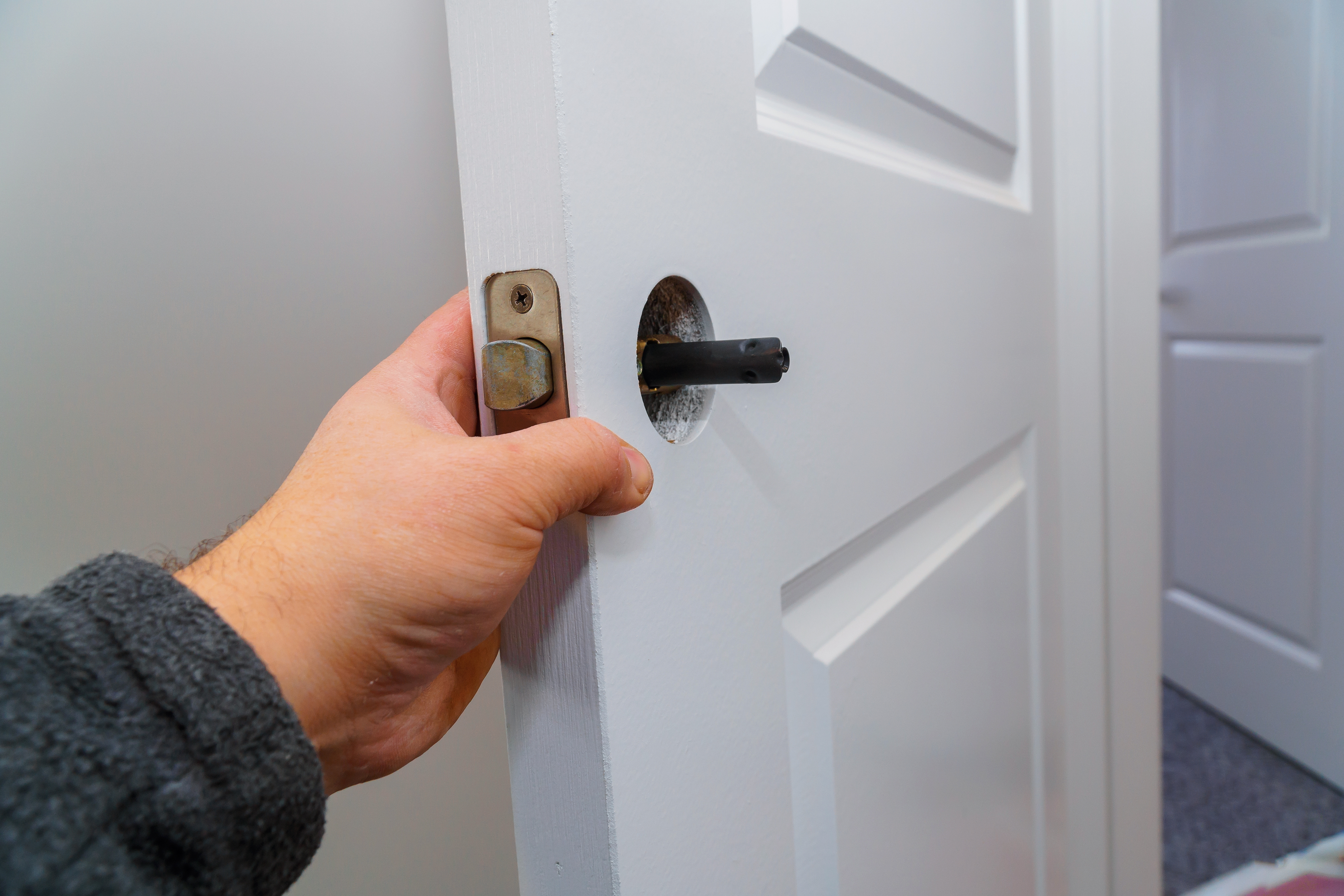 hands-repairing-a-door-lock-with-a-door-knobs-2022-11-12-10-42-07-utc.jpg