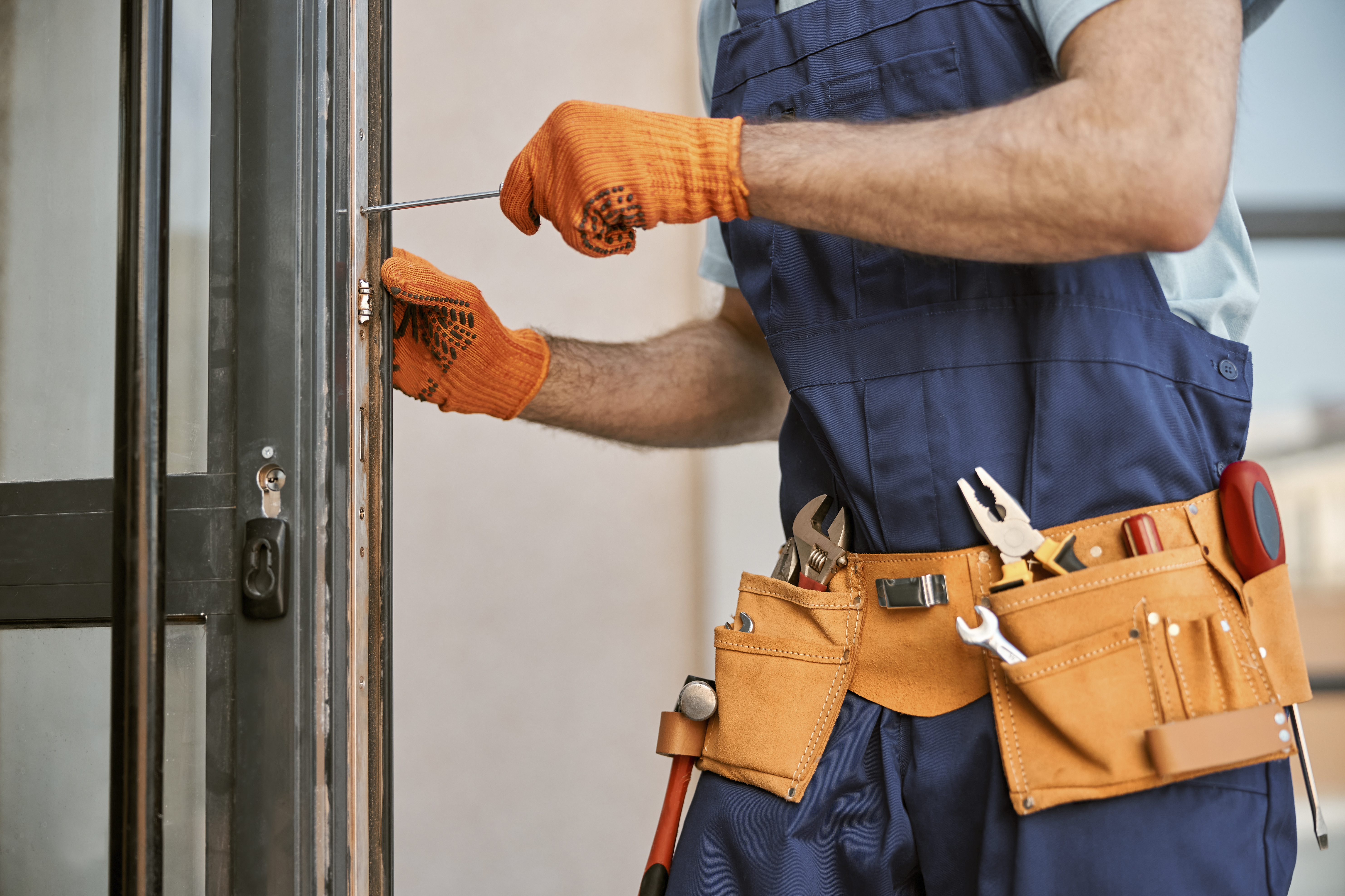 male-hands-in-gloves-repairing-door-in-h